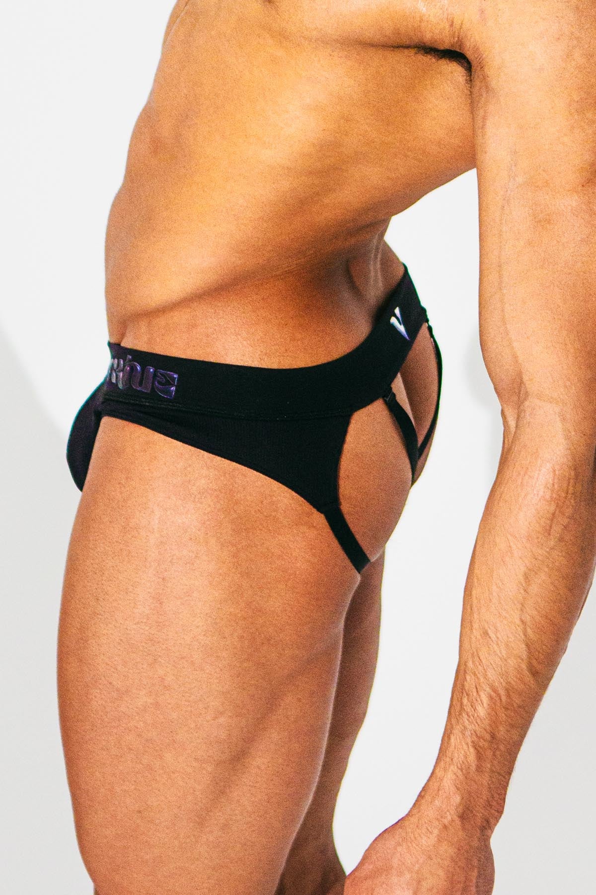 Virtue Model posing in Black Strap Brief a Reimagined Genderless Jockstrap Side View