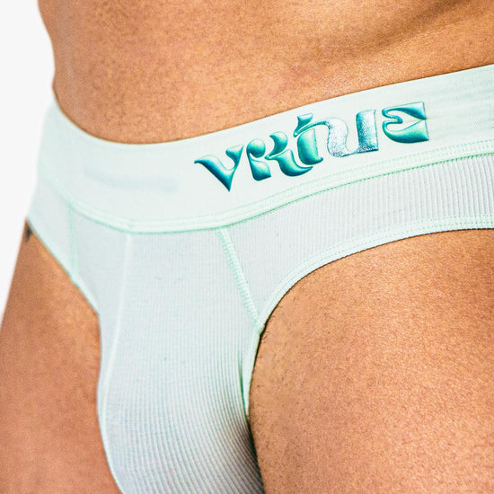 Close-up of a model adjusting the straps of the mint Sculpt Jockstrap Rib Brief, back view — Fabric: Rib — Color: Mint
