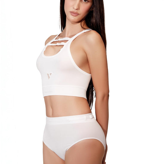 Model wearing Women’s white rib-knit underwear, Core Rib Brief, front view with hands behind her back — Color: white